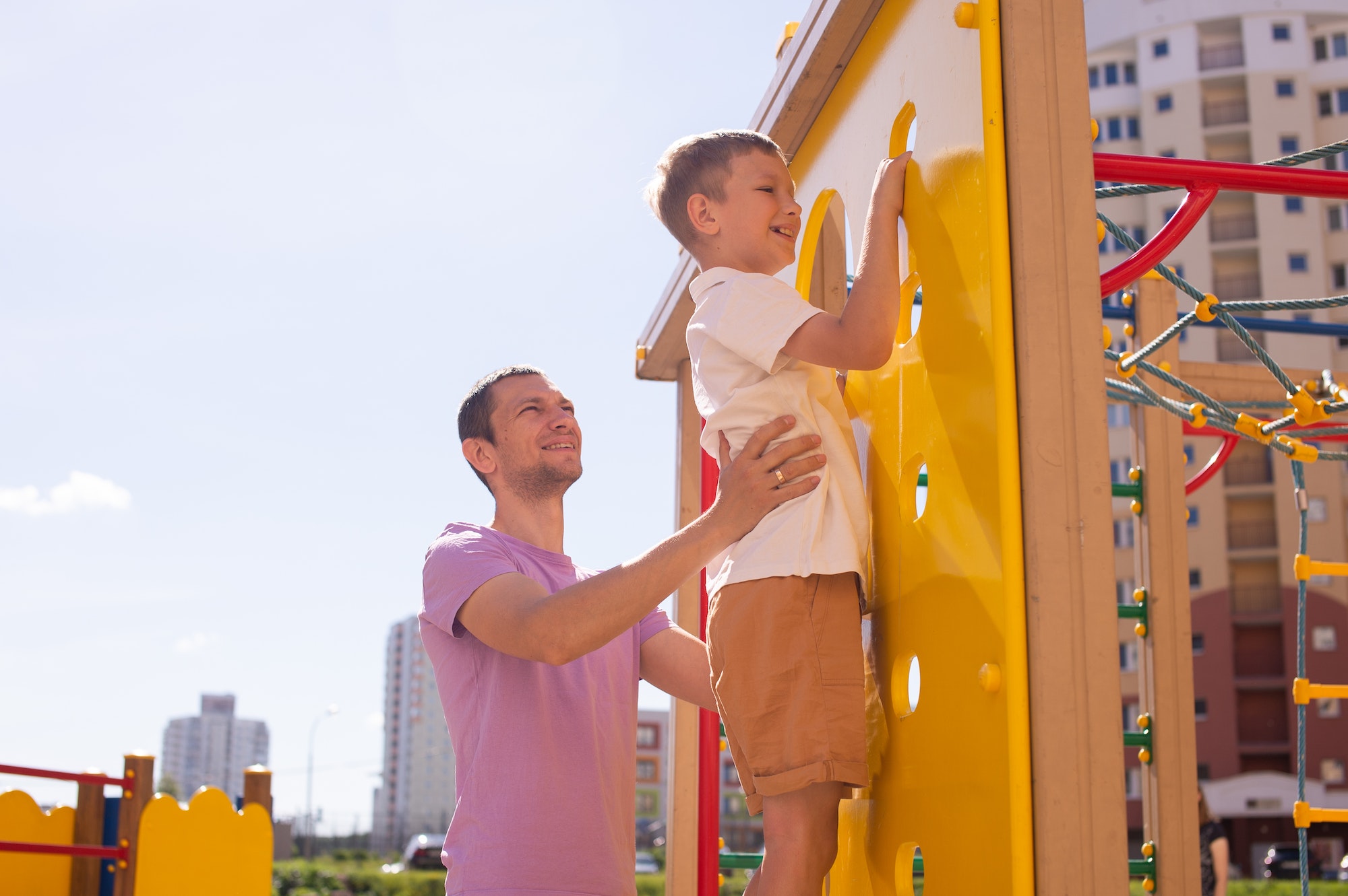 Cute baby and daddy play on the playground